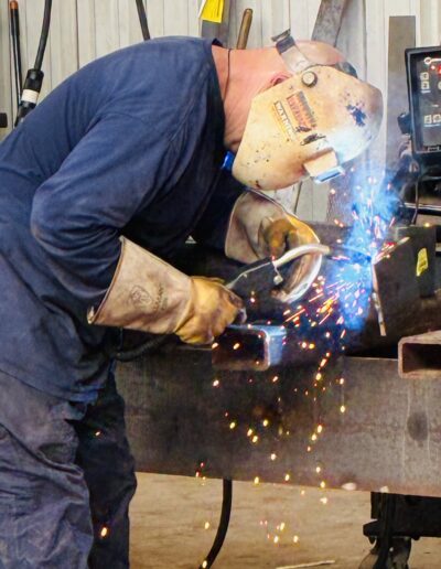 man welding adjustable column