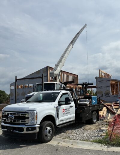 f350 truck with royal metal logo with boom truck and jobsite in background