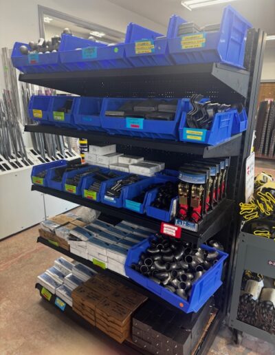 metal accessories and supplies in blue bins on shelf