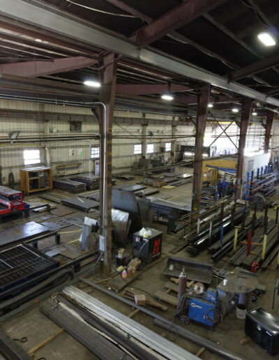 inside of commercial warehouse. there is machinery and stacks of steel