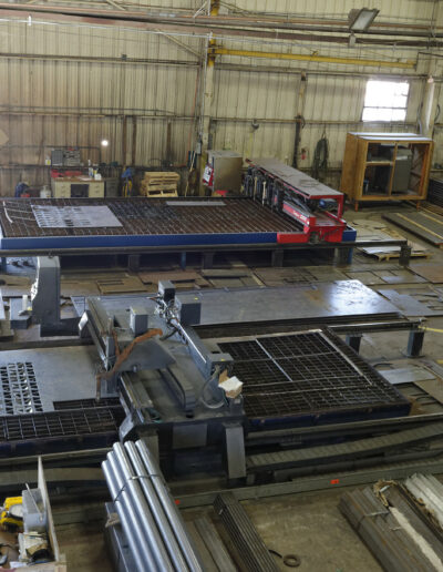 inside of commercial warehouse. there is machinery and stacks of steel